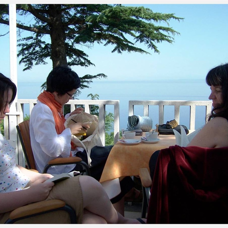 writers talking at a table next to the ocean